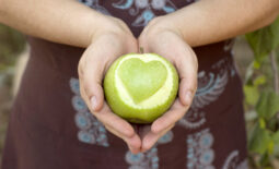 Hands,Holding,An,Apple,With,Heart,Shape,Cut,Out